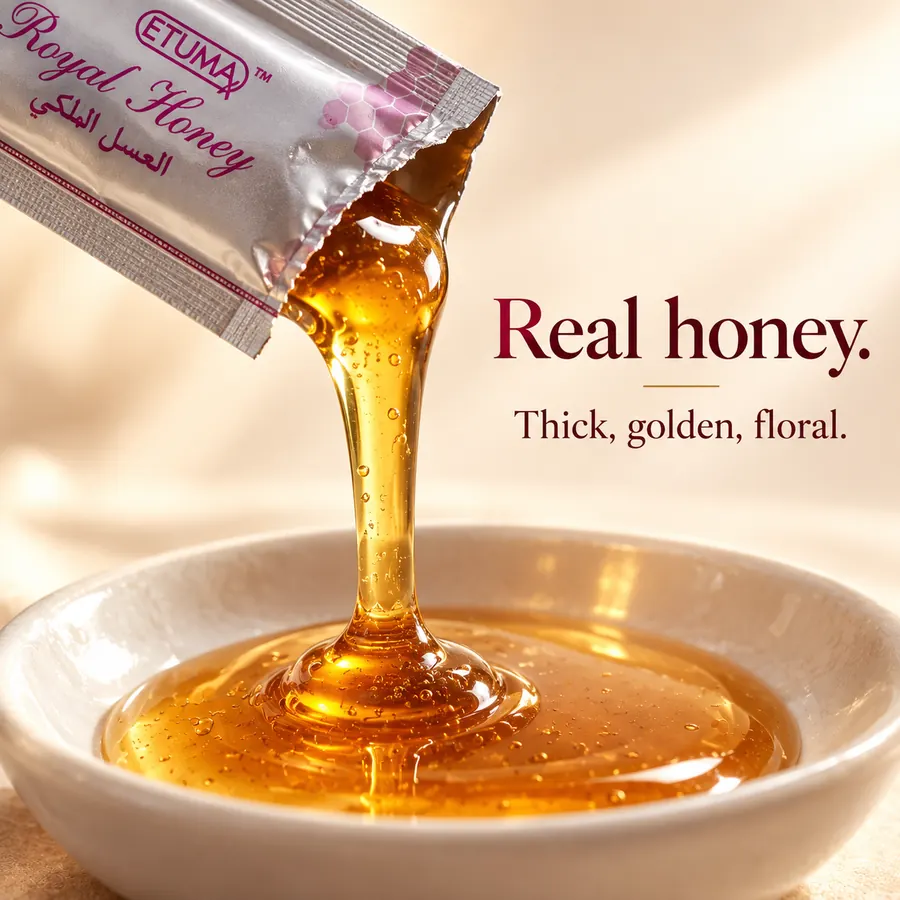 Golden honey pouring from an opened sachet into a dish